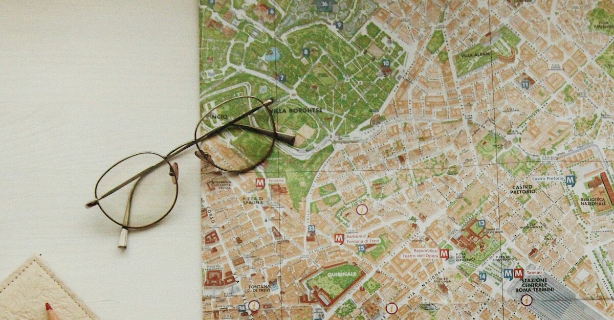 A pair of glasses sits on top of a map with property outlines