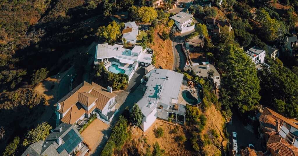 A drone shot of Los Angeles hills' single family homes, that sit above multifamily apartments.