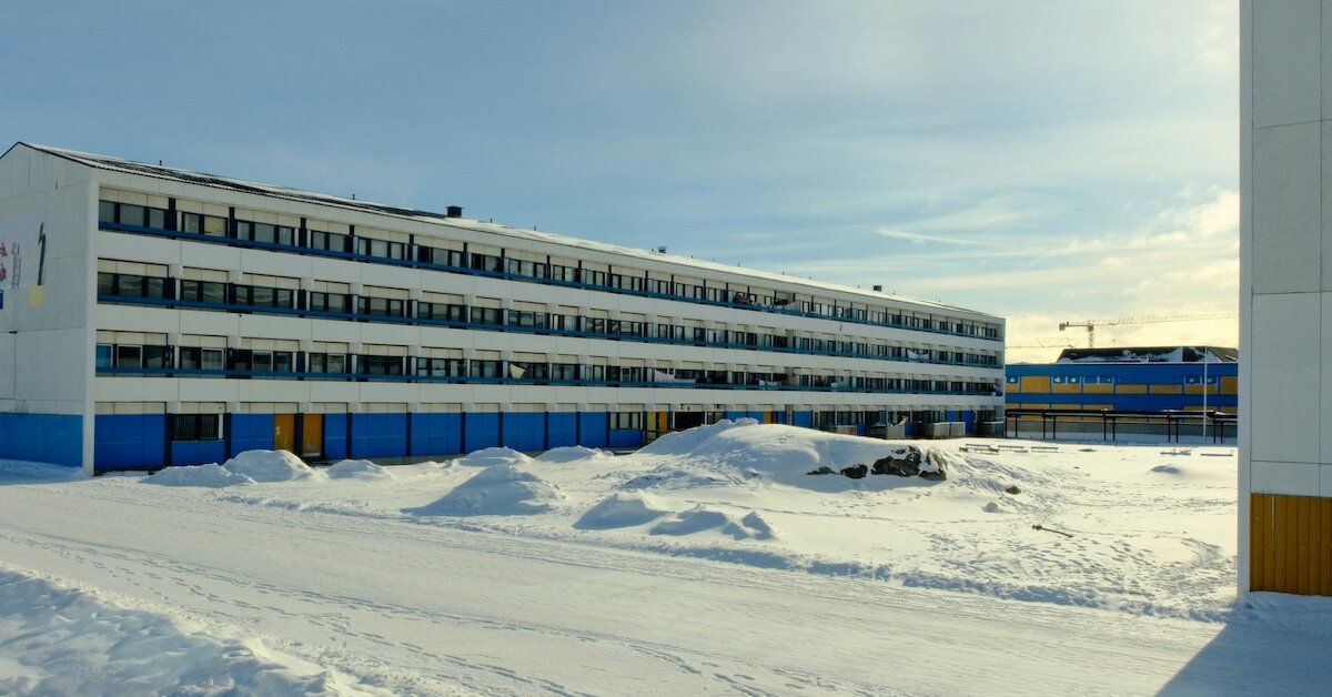 A building with piles of snow in the foreground