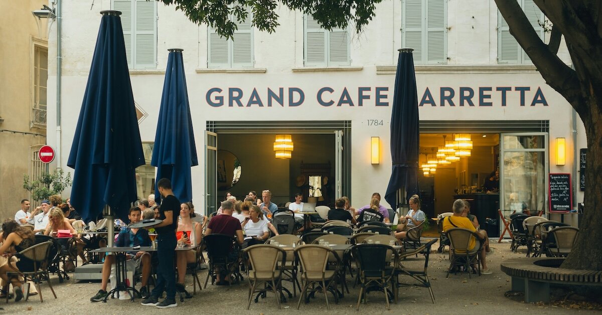 The outdoor terrace of a retail restaurant with diners sitting at al fresco tables