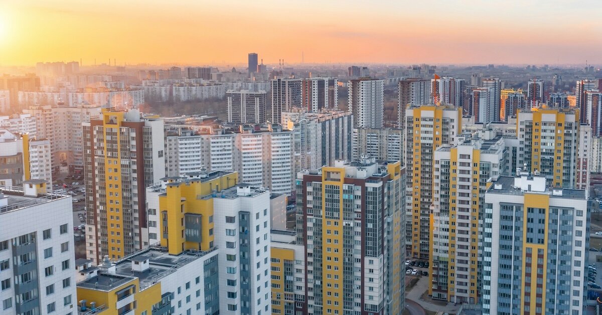 A group of yellow and white colored tall buildings at sunset