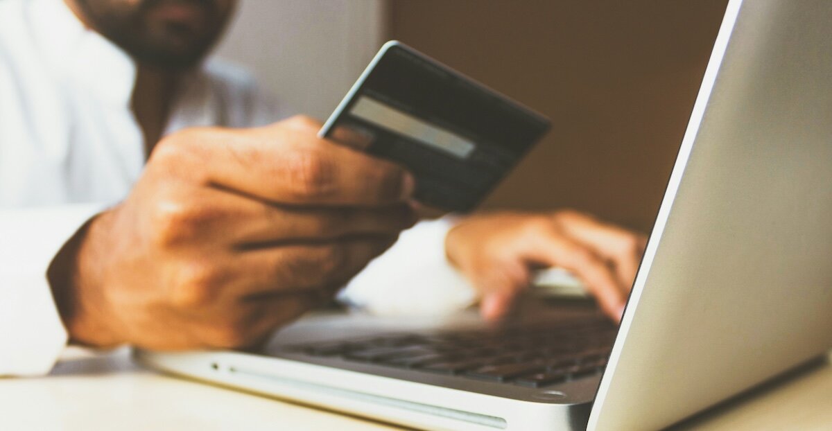 a person on their laptop inputs their credit card information