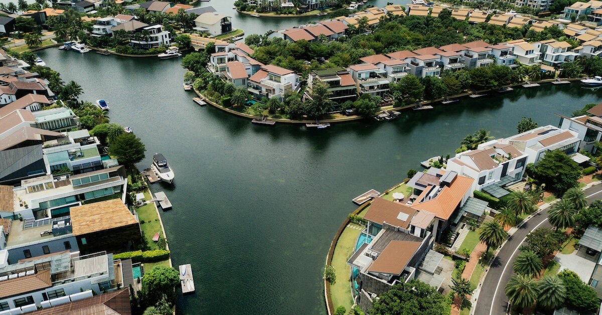 A view of several single family rental properties along a river with boats at residential docks