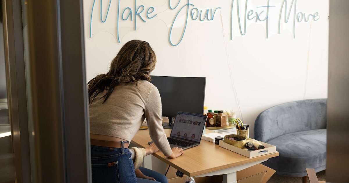A Crexi employee is reviewing the Crexi website in an office with a coworker