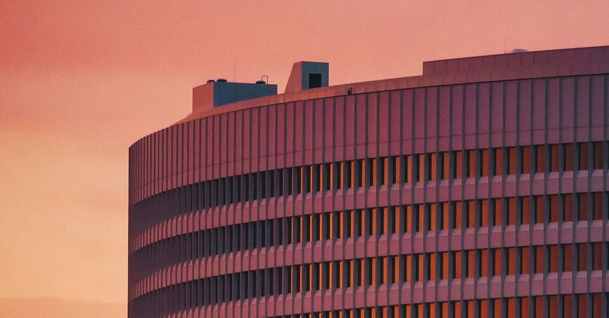 a large office building reflecting a red sunset