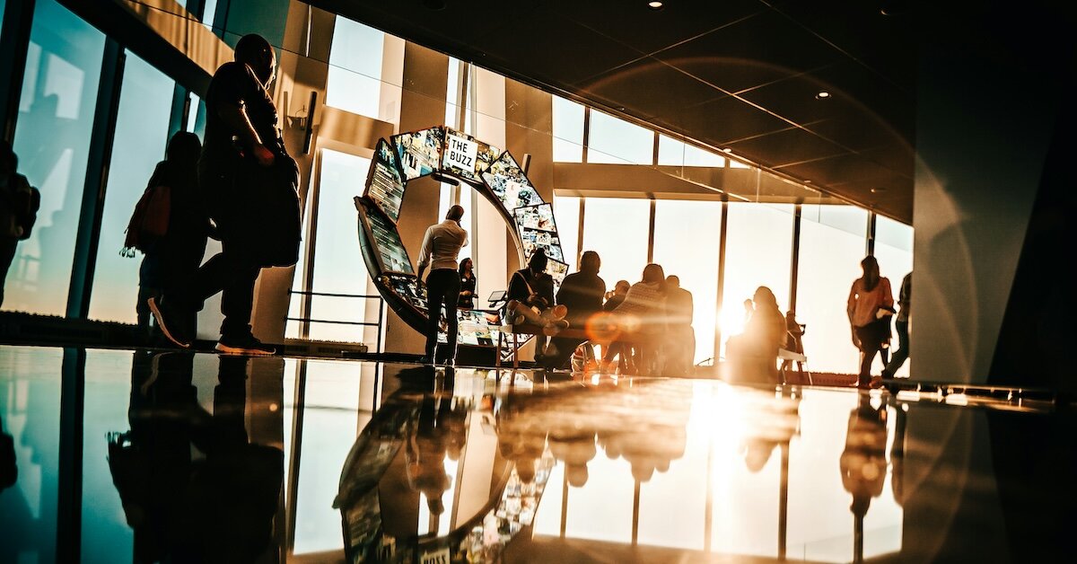 Office workers walking through the lobby of a commercial office building flooded in sunlight
