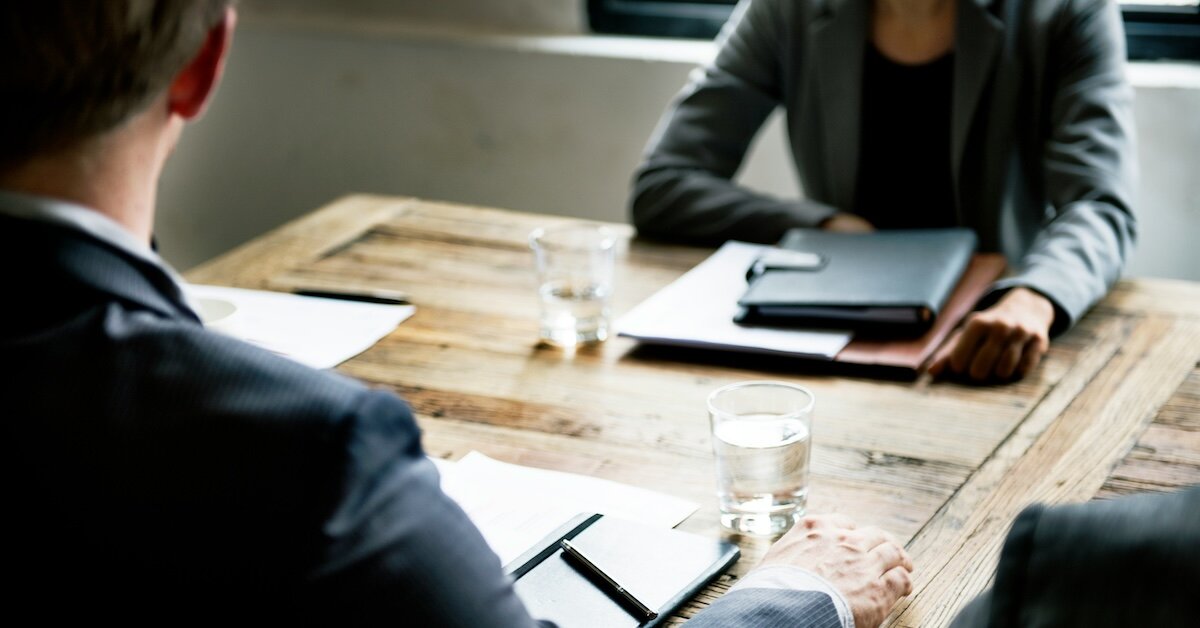 two people in an office sitting across a table from eachother