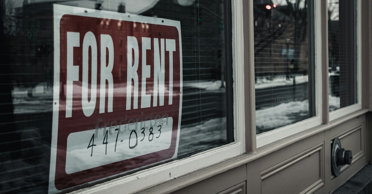 A building with a for rent sign posted in the window