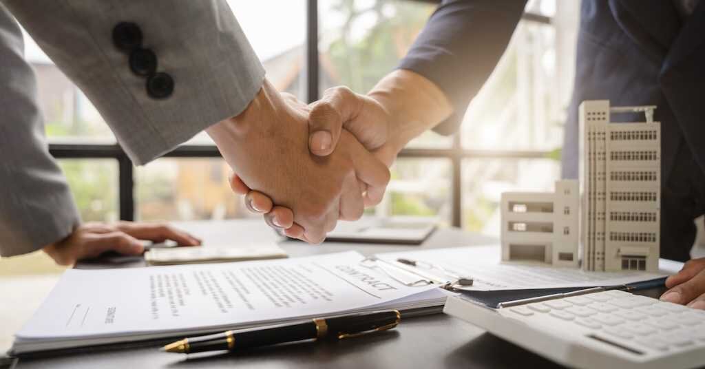 Close up shake hands, Considering buying a home, investing in real estate. Broker signs a sales agreement. agent, lease agreement, successful deal.