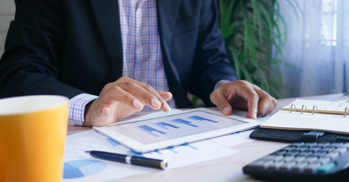 Man interacting with bar graphs on a tablet while working.