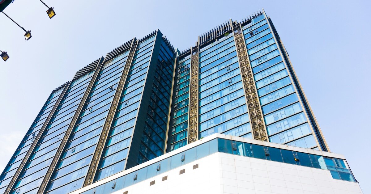 two tall buildings connected and with blue glass windows