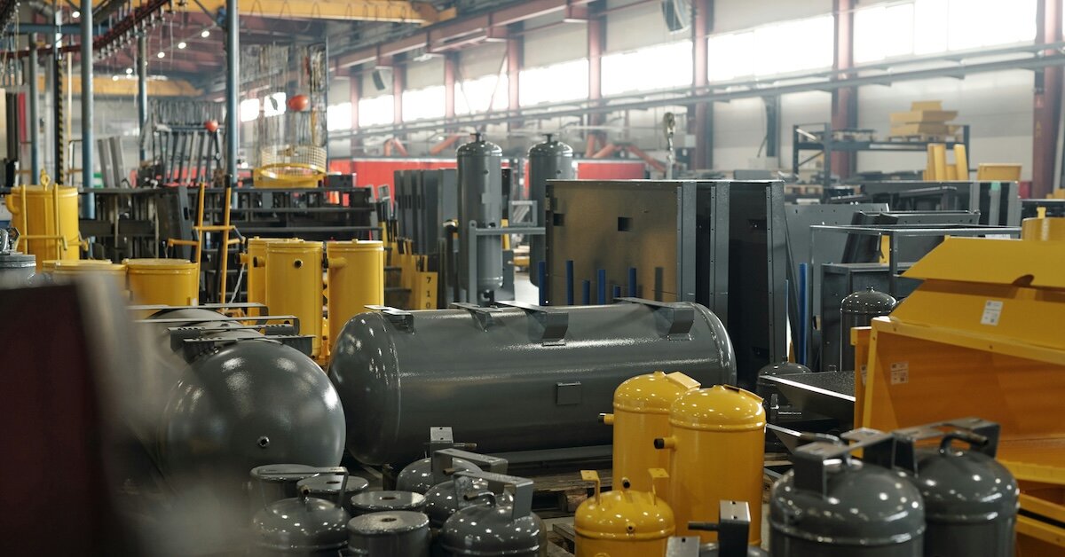 The inside of an industrial warehouse with factor components and machines in steel and yellow colors.