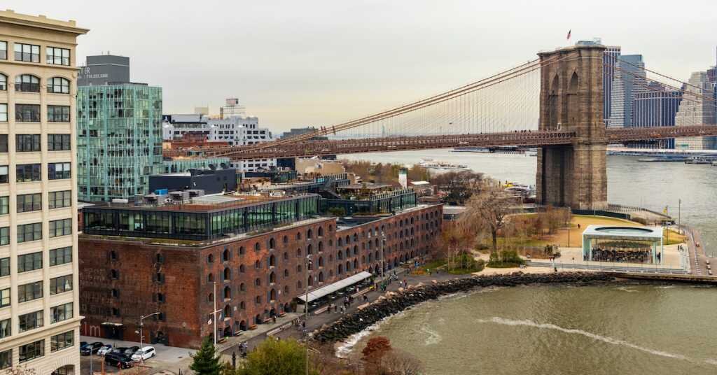 View of DUMBO, including the Brooklyn Bridge, Empire Fulton Ferry Park, Jane's Carousel, and Empire Stores
