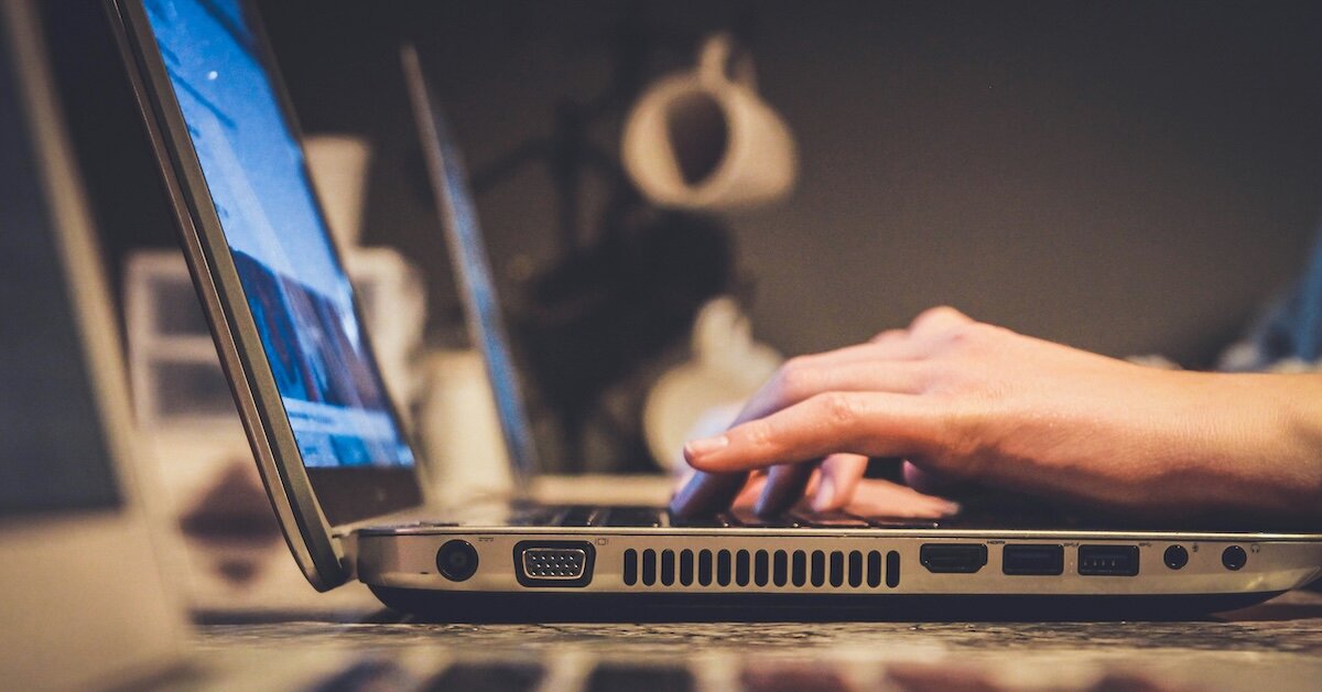 A professional typing on their laptop