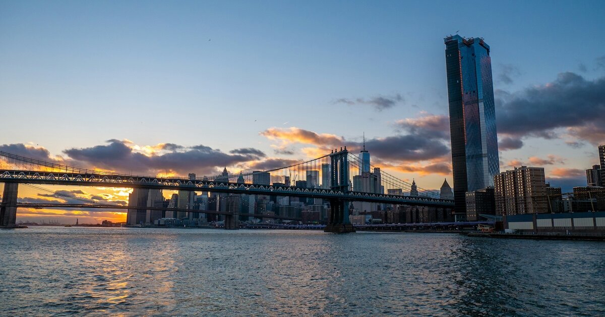 A view of Manhattan from a sunset-lit bridge