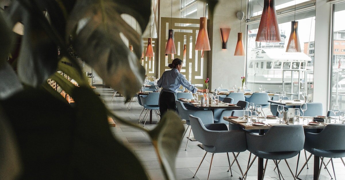 a hostess sets tables inside a hotel restaurant