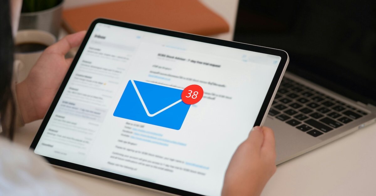 An ipad with a giant mail icon on top of an inbox