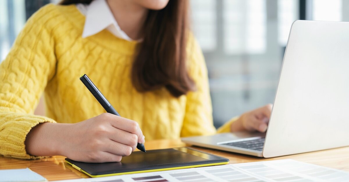 a person with a laptop tablet using a stylus