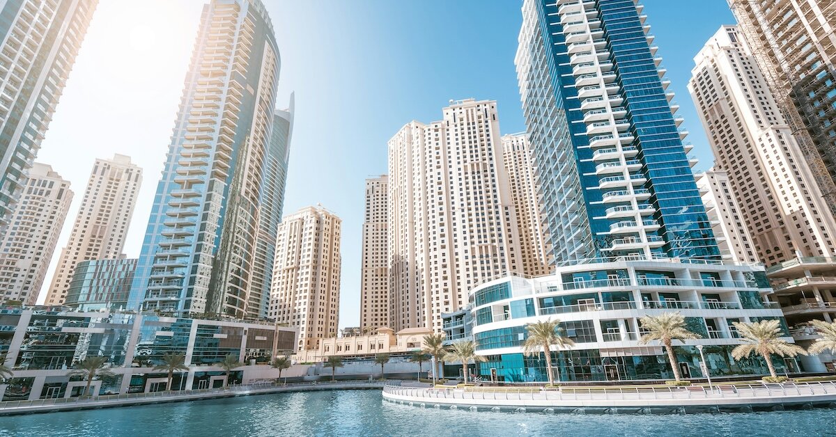 a downtown central district with shining tall buildings by the ocean water