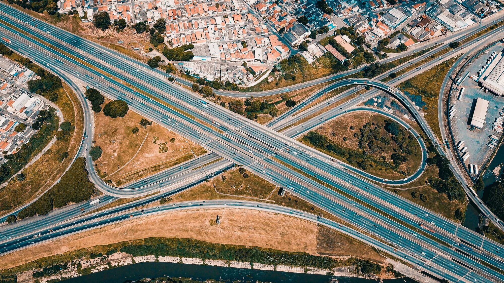 A freeway interchange with empty land and suburban housing tracts surrounding