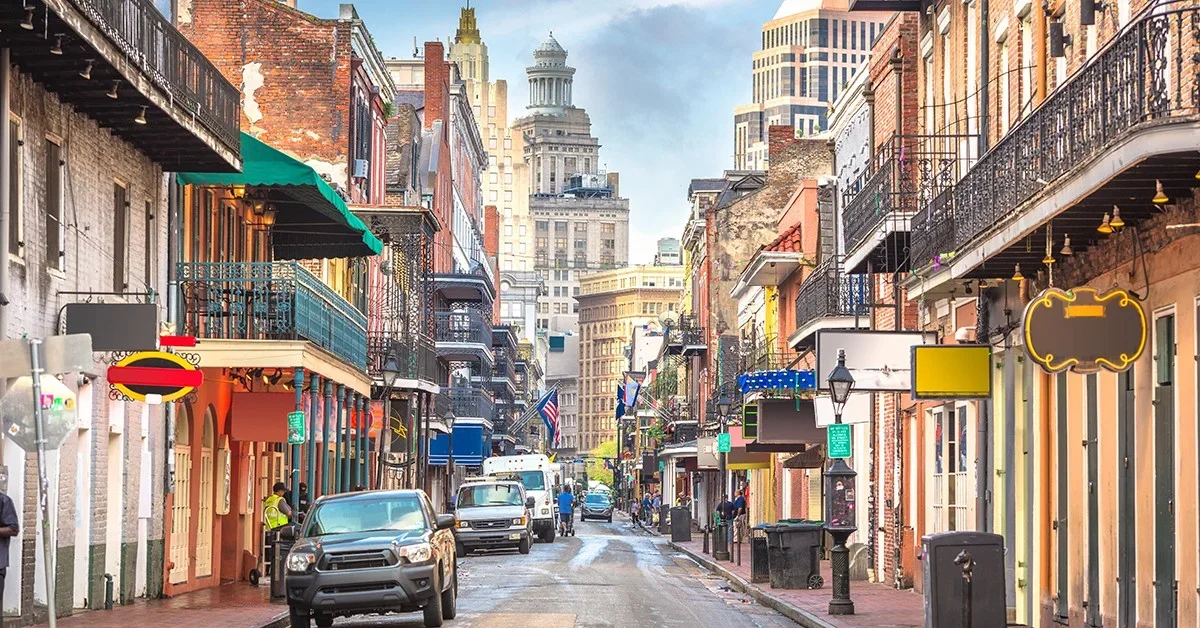 Downtown New Orleans street lines with shops and vehicles