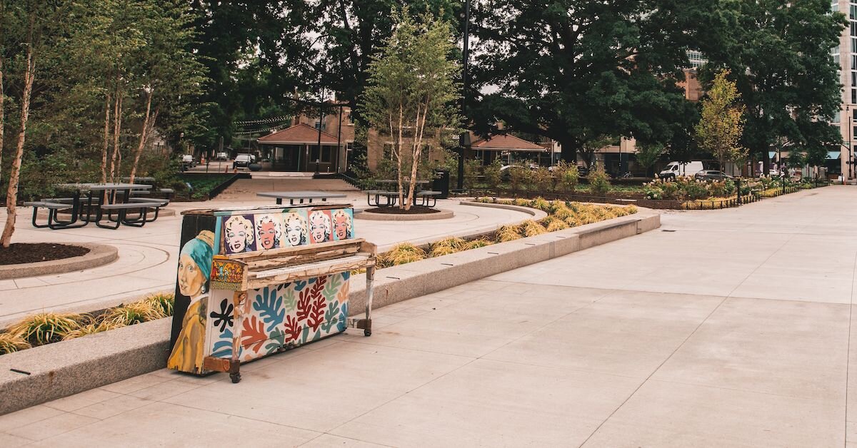 A painted upright piano standing in a Raleigh park