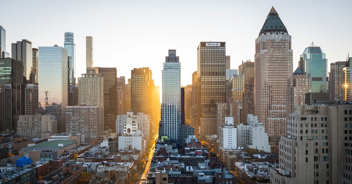 The New York City skyline with the sun setting behind the skyscrapers
