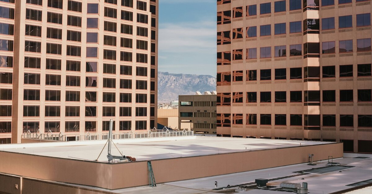 The top of a commercial building flanked by taller buildings on each side