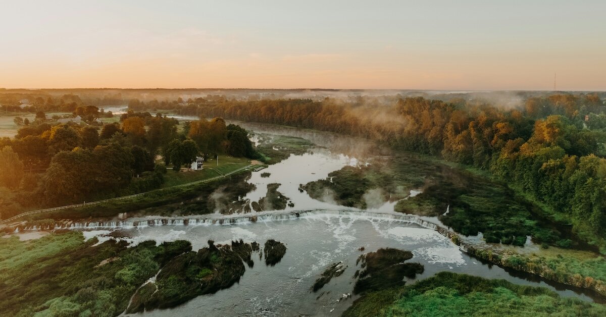 A waterfall flows onto a plain, flooding some farmlands