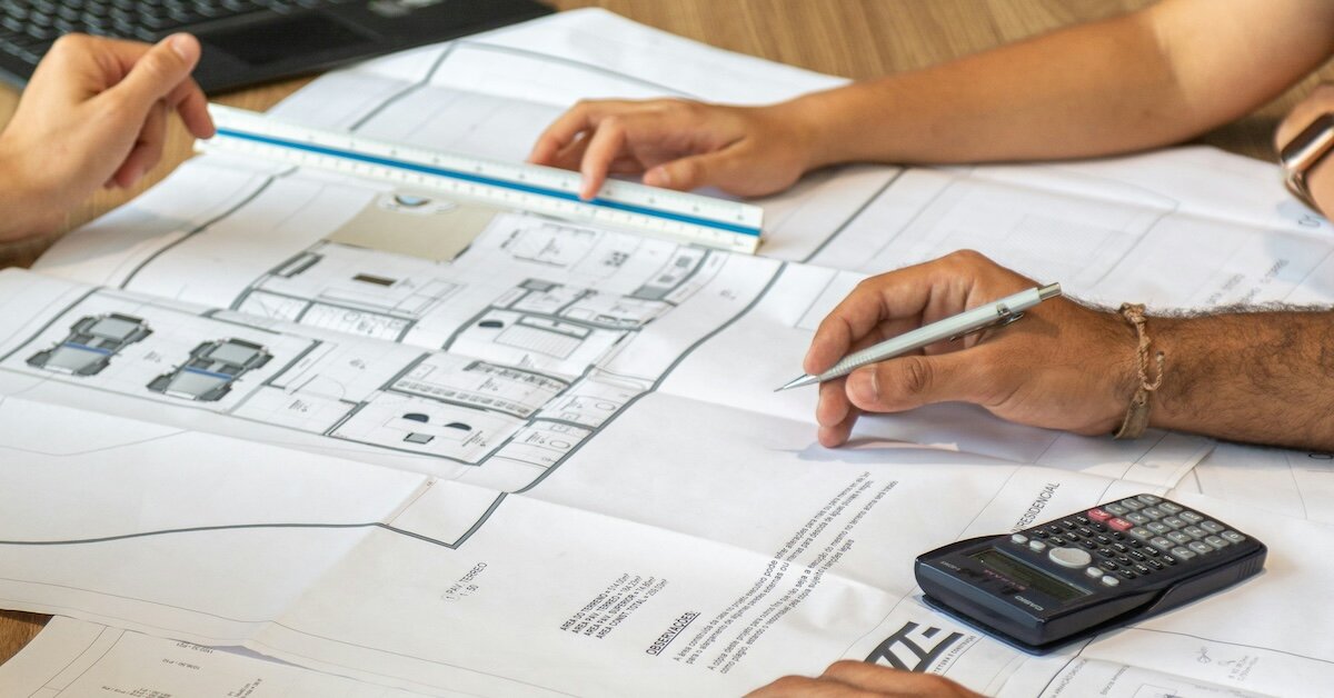 People meet reviewing building plans to calculate valuations