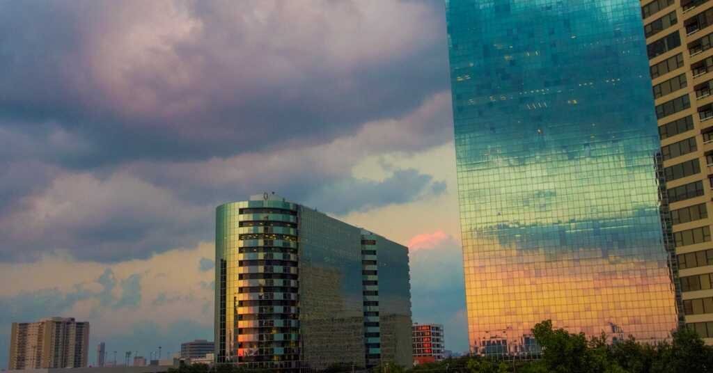 A sunset view reflected on Houston tall buildings in rainbow colors