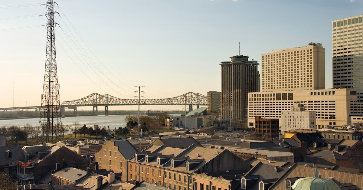 The New Orleans cityscape with multifamily buildings in the foreground and the Mississippi River in the background