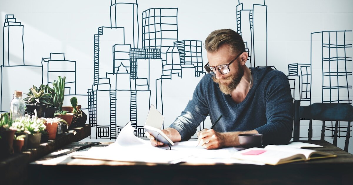 a man holds a calculator and a pencil while reviewing sales comps for an appraisal