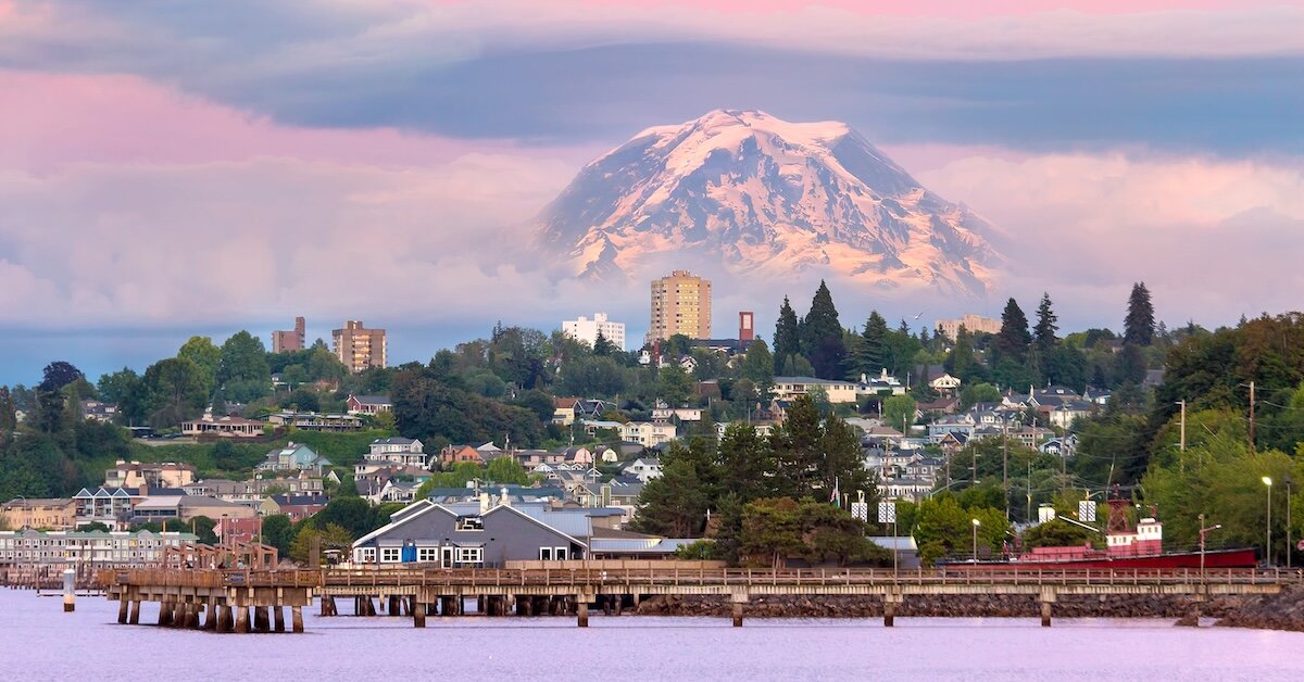 The city of Tacoma has office towers and a large mountain in the background