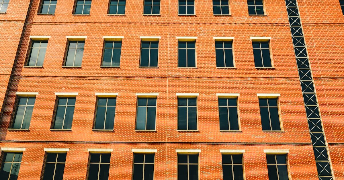 A brown brick commercial property with many windows