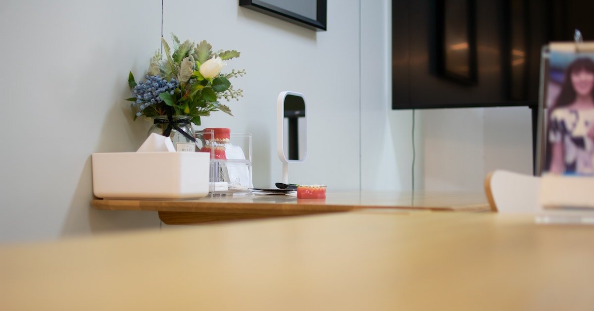 Desk-level view of a reception desk with teeth models and a tissue box on in view.