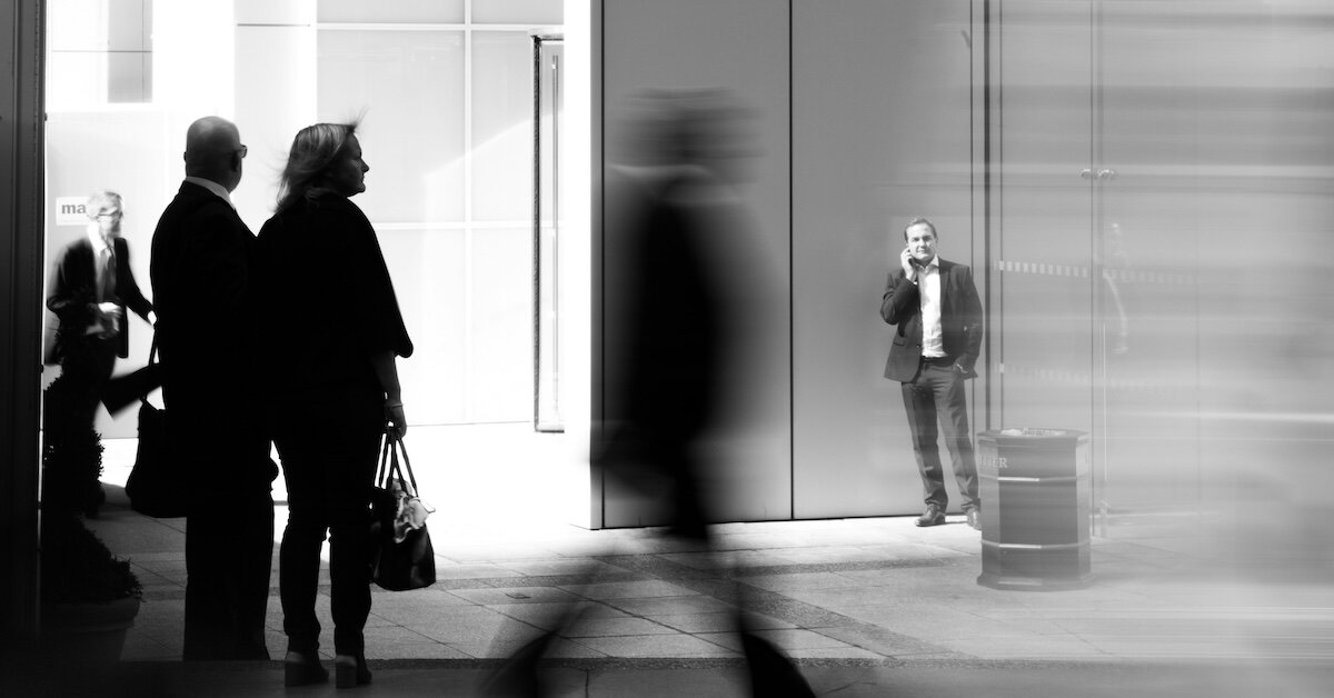 People walking fast in front of a commercial building