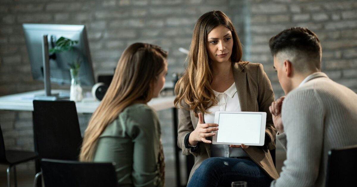 woman showing two business partners a loading tablet page