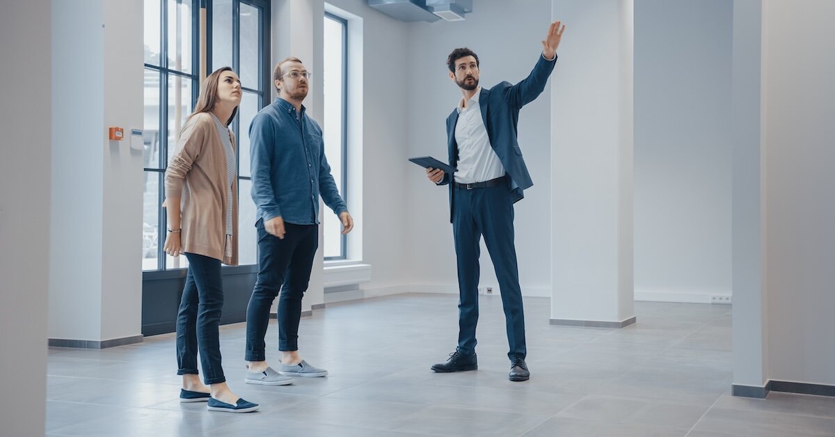 A broker gives two professionals a tour of a commercial office