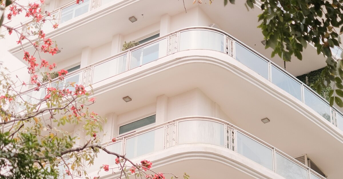 Trees frame the upper few floors of an apartment building