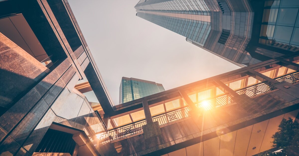 Sunset shines through a bridge connecting two commercial buildings