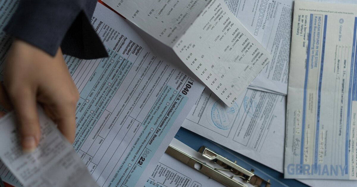 a pile of empty tax forms, receipts and paperwork lies on a desk