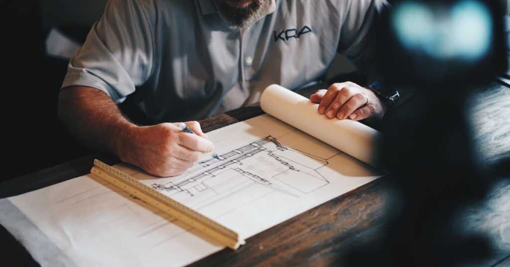 Man sketching architecture designs on paper.