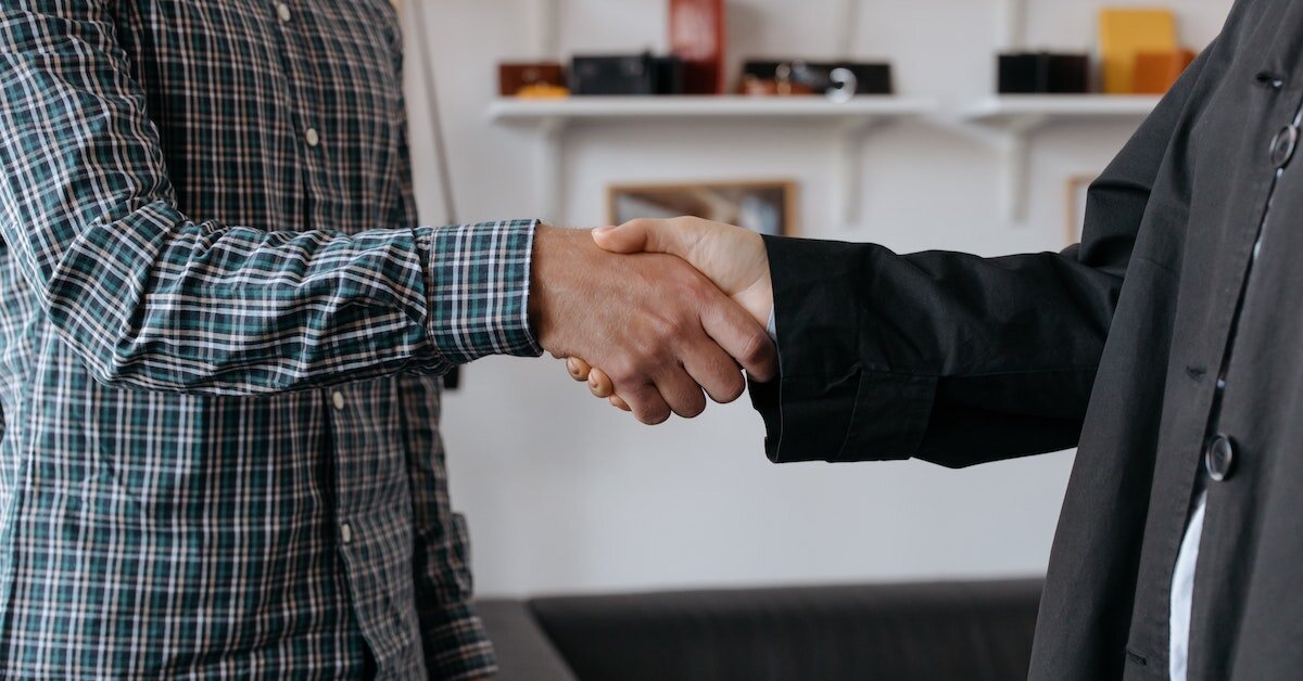Two men shake hands.