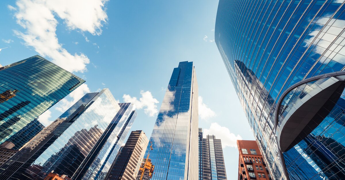 skyline of tall buildings with sky reflecting