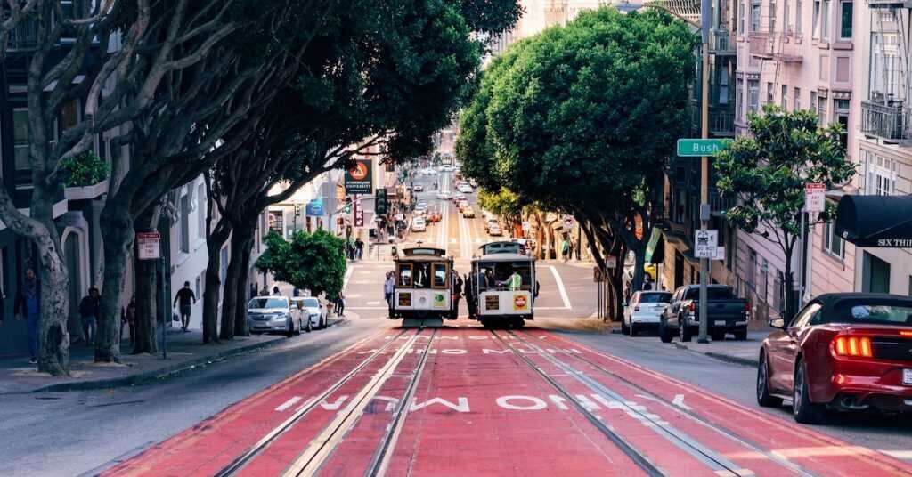 Two trolley cars rolling up a hill side by side in San Francisco