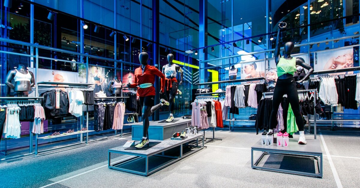 The inside of a colorful Nike store, with bright clothes on the mannequins