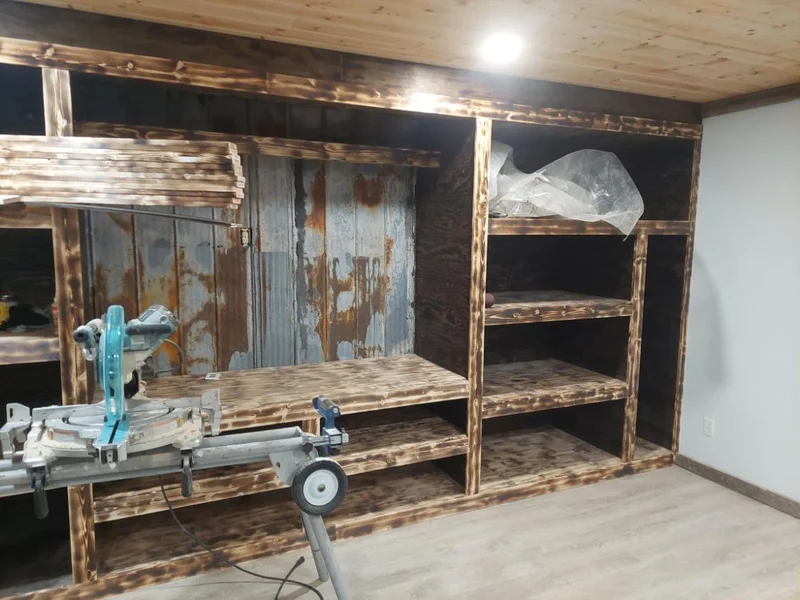 Built-in dark stained wood storage wall under construction