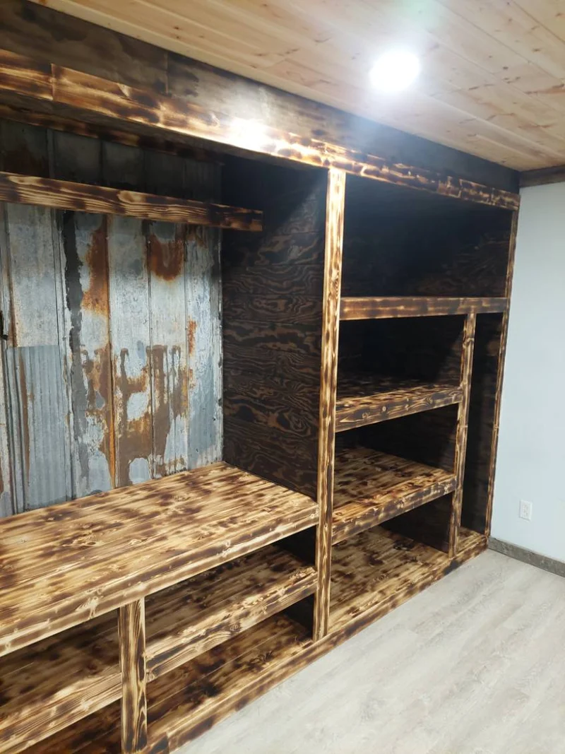 Stained wood media wall with shelving and a corrugated metal feature panel