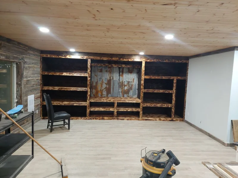 Wide stained wood built-in shelving and media wall in a finished room